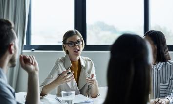 woman speaking to group at table