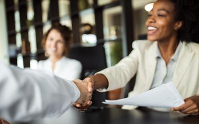 Woman shaking hands across conference room table