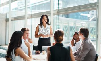 Person standing in front of table of 5 people