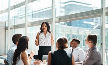 Person presenting to a group of people in an office building