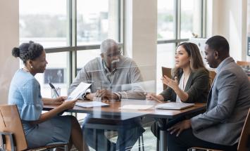 Group of four people chatting around a table