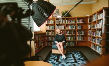 Person sitting on chair in front of a videocamera