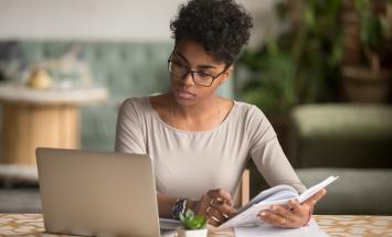 Person with open laptop and notebook