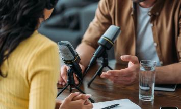 Man and woman conducting a podcast interview