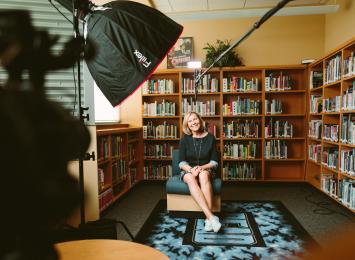 Person sitting on chair in front of a videocamera