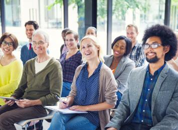 Person smiling in a seated group of other people