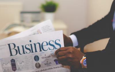 Person holding Business section of newspaper