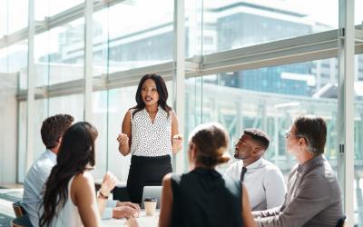 Person presenting to a group of people in an office building