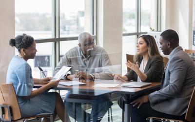 Group of four people chatting around a table