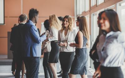 people standing up in the hallway of an event and talking to each other