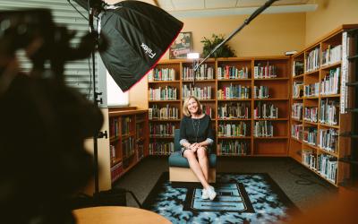 Person sitting on chair in front of a videocamera