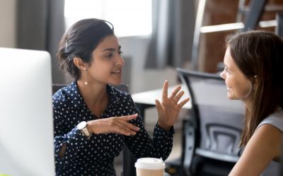 two people chatting in front of a computer