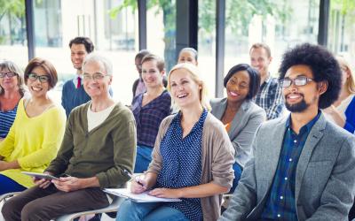 Person smiling in a seated group of other people