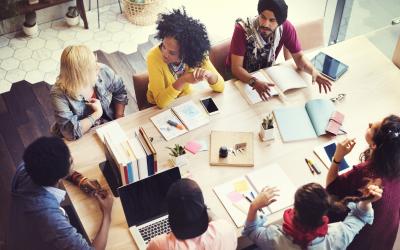 Group of people, eagle eye view, around a table working