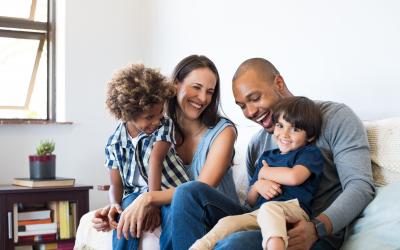 Two adults and two children hanging out on a couch