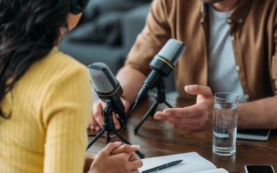 Man and woman conducting a podcast interview