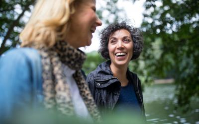 two people walking in the park smiling and laughing