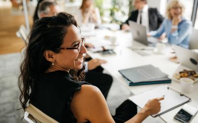 Woman sitting at table with clipboard